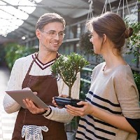 man selling a plant to a woman