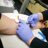 person drawing a patients blood